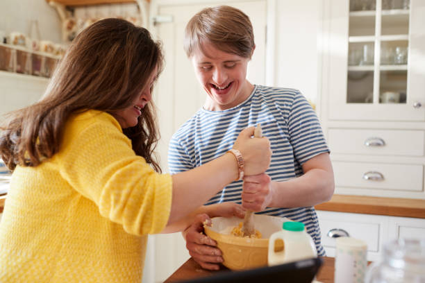 istock Young Downs Syndrome Couple Baking In Kitchen At Home 1149275259