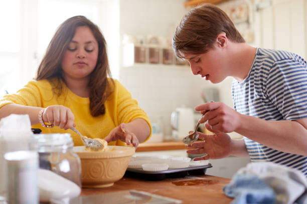 istock Young Downs Syndrome Couple Baking Cupcakes In Kitchen At Home 1149277057