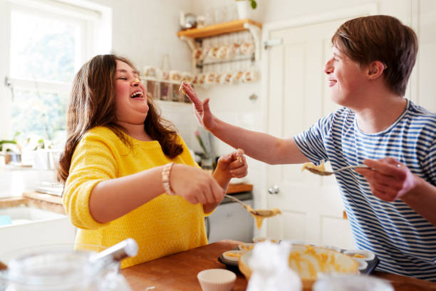 istock Young Downs Syndrome Couple Having Fun Baking Cupcakes In Kitchen At Home 1149277222