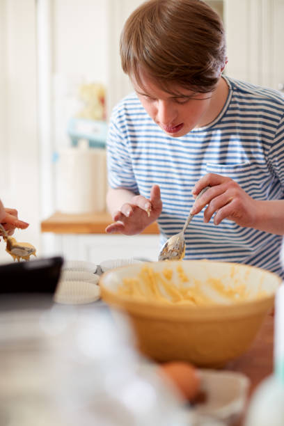 istock Young Downs Syndrome Man Baking Cupcakes In Kitchen At Home 1149277651
