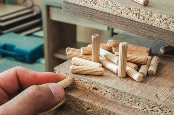 Furniture fittings, wooden dowels for joining furniture elements from chipboard, close-up
