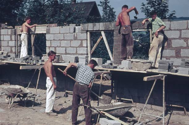 muratore (artigiano) costruisce un muro di casa - historical site foto e immagini stock