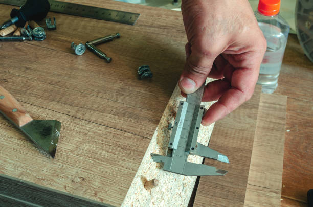 istock Carpenter measures the holes made with a caliper 1149281696