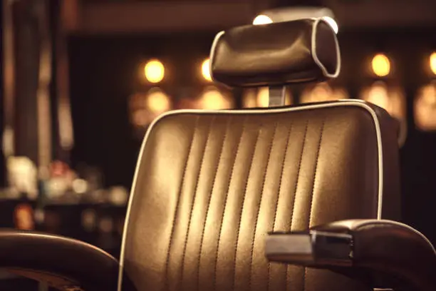 Photo of Brown leather chair in barbershop. Loft style