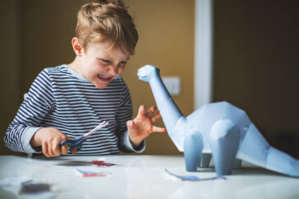 istock Kid playing with toy dinosaur 1149283557