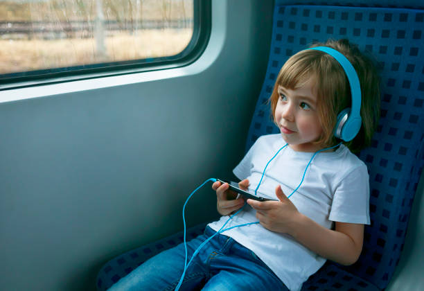 電車の中でスマートフォンを使用�して小さな子供 - one little boy audio ストックフォトと画像