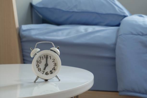 istock White alarm clock at 7 o'clock on the white table in bedroom 1149285366