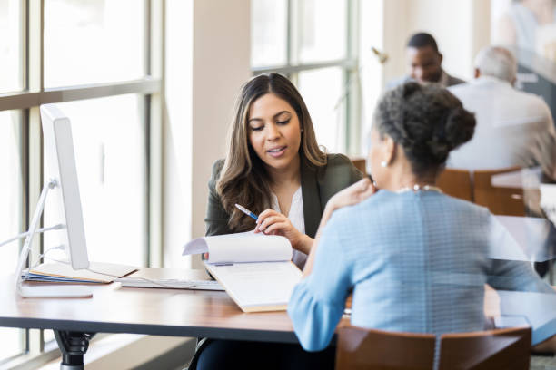 istock Mixed race bank manager shows current loan offers 1149285470