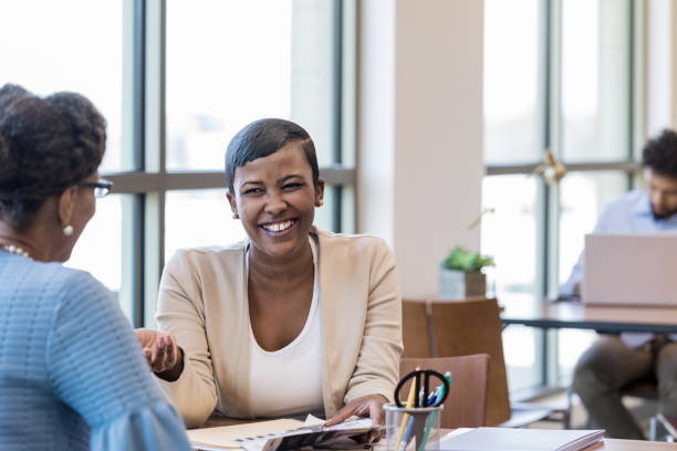 istock Mid adult banker and unrecognizable customer share a laugh 1149285636