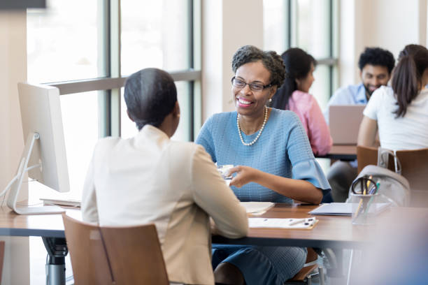 istock Bank representative hands African American customer a brochure 1149285640