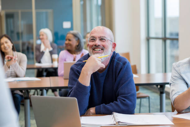 Students in adult ed class have fun Diverse group of students have fun during their adult ed class at the local college. education event stock pictures, royalty-free photos & images