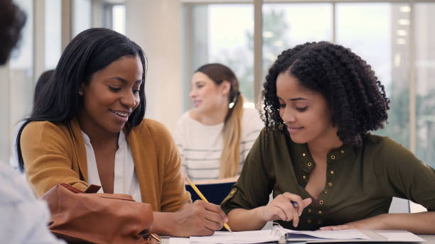 istock Cheerful tutor helps college student with research paper 1149286341
