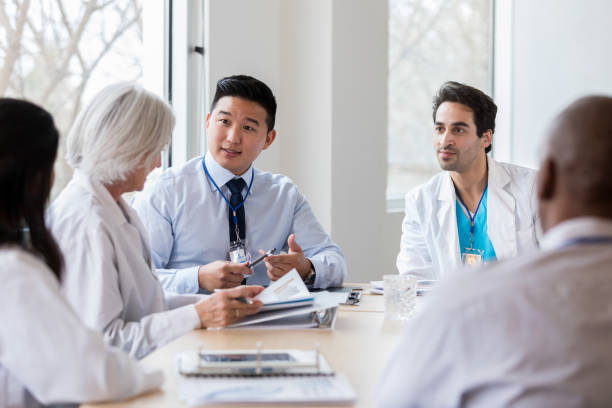 o administrador do hospital masculino fala com doutor fêmea - doctor business person teamwork meeting - fotografias e filmes do acervo