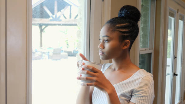 istock Introspective young woman daydreams at home 1149286471