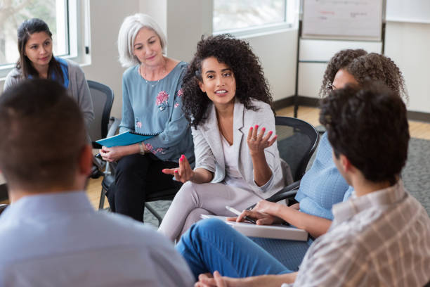 istock Mixed race female emphatically addresses the group 1149286680
