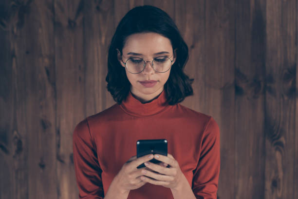 Close up photo serious focused boss chairman use user modern technology device read search news information brunette hair hairstyle dressed modern specs red trendy stylish style pullover industrial