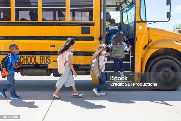 Los Niños De La Escuela Primaria Se Alinean Y Se Sube Al Autobús Foto de stock y más banco de imágenes de Niño