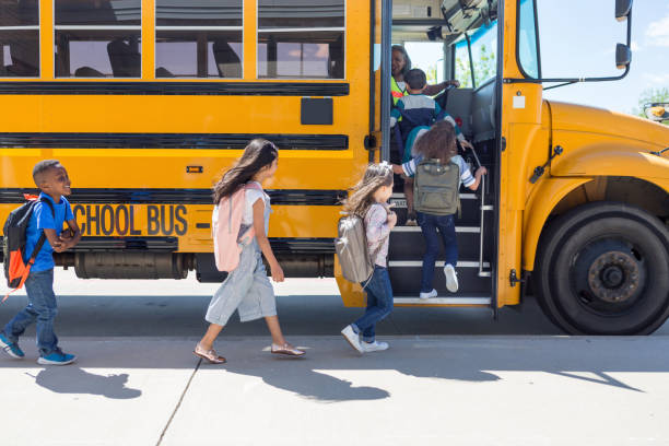 istock Elementary school children line up and get on bus 1149286861