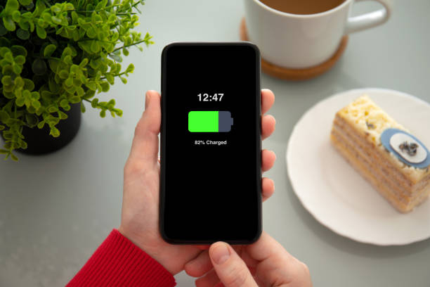 istock female hands holding phone with charged battery on the screen 1149287175