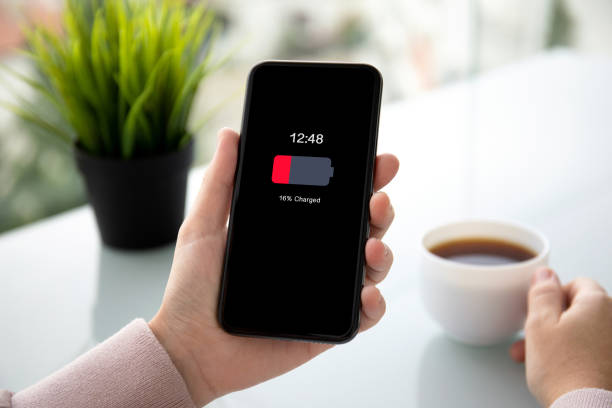 istock female hands holding phone with low charged battery on screen 1149287340