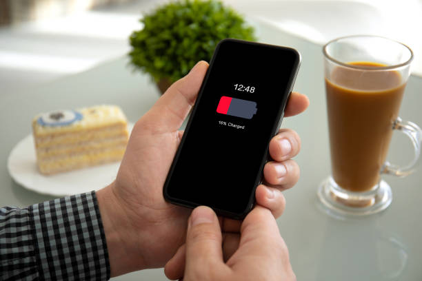 istock male hands holding phone with low charged battery on screen 1149287899