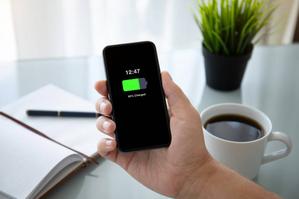 istock man hand holding phone with charged battery on the screen 1149288064
