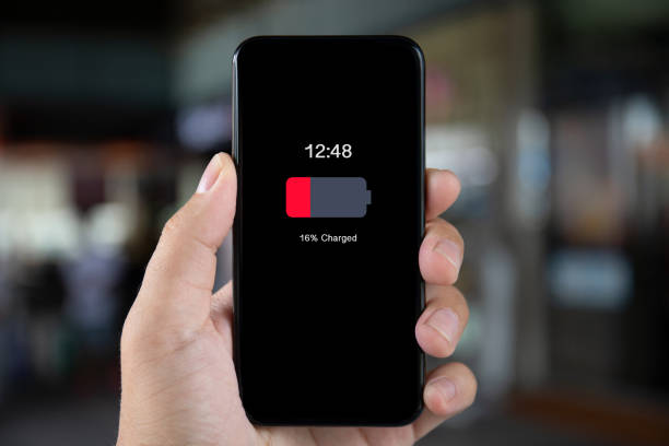 istock man hand holding phone with low charged battery on screen 1149288132