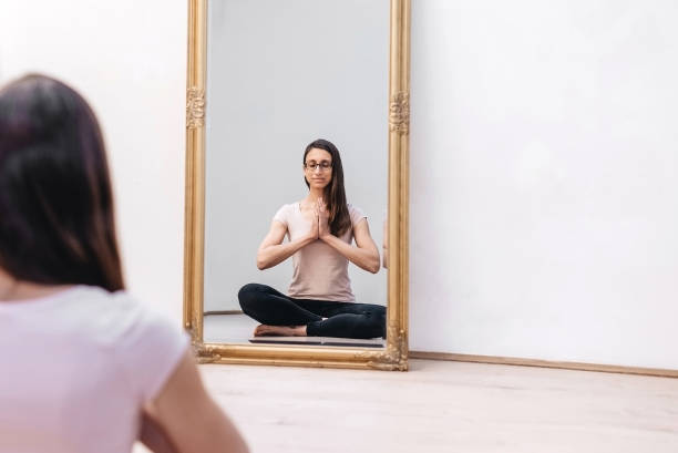 istock Mirror reflection of a young woman practicing yoga 1149288541