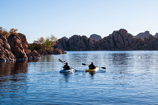 Prescott, Arizona, USA 04/24/2019 A man and woman kayaking on the early morning on Watson Lake under blue skies