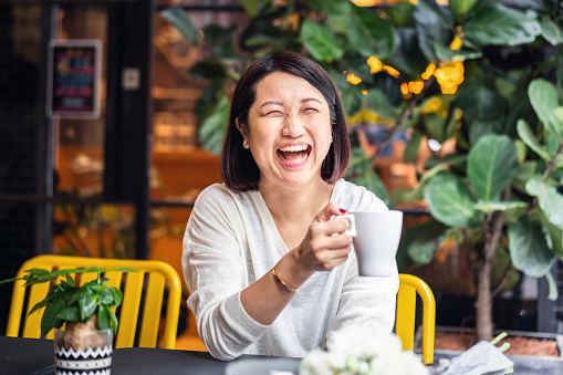 Laughing Chinese woman in a cafe.