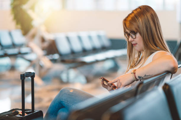 istock Young woman looking at her mobile phone before flight 1149293784