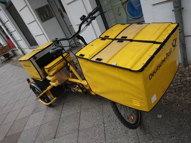 tedesco deutsche post bici gialla - deutsche post ag package germany occupation foto e immagini stock