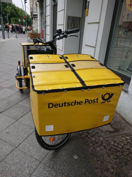 deutsche post gelbes fahrrad - messenger deutsche post ag package germany stock-fotos und bilder