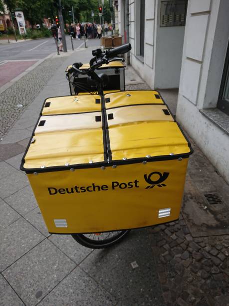 tedesco deutsche post bici gialla - deutsche post ag package germany occupation foto e immagini stock