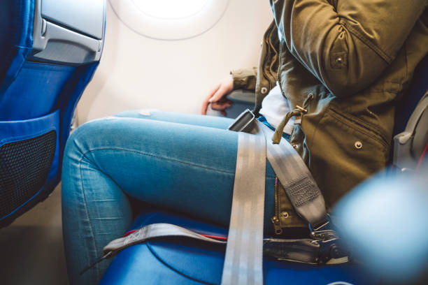 istock Girl sitting on a plane with fasten seat belt. 1149295331