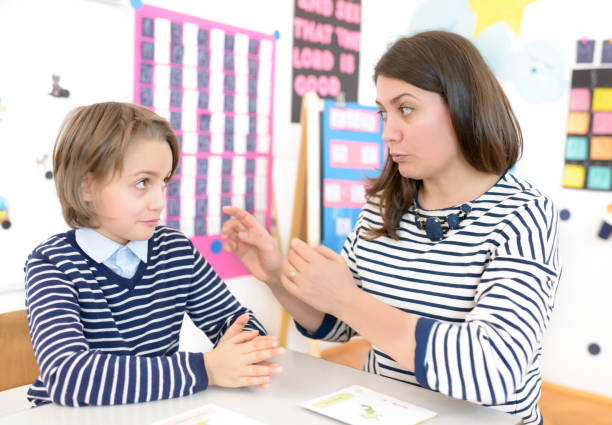 speech therapist during private language lesson at office - medical exam doctor patient adult imagens e fotografias de stock