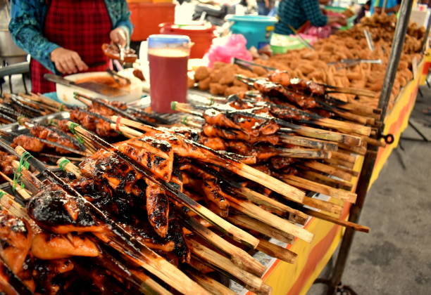 istock Barbecued chicken on bamboo sticks on a table at a Penang market 1149298207