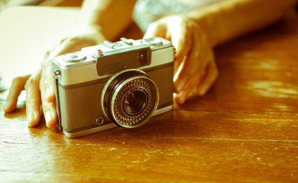 istock Vintage film camera on wooden table. 1149298490