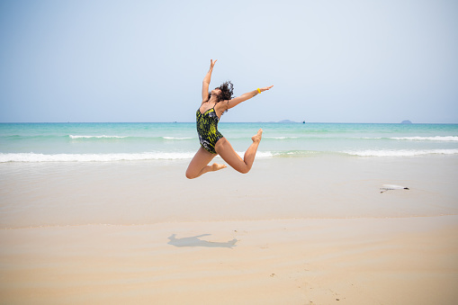 Life - live it up. young woman spoiled dancing at beach