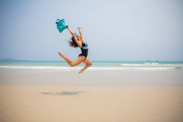 istock Female Gymnast Jumping on the beach 1149299444