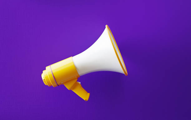 Yellow Megaphone On Purple Background Yellow megaphone on purple background. Horizontal composition with copy space. Great use for announcement concepts. commercial event stock pictures, royalty-free photos & images