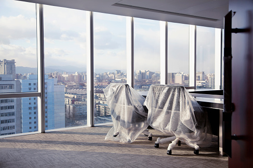 Sillas de oficina cubiertas con envoltura de burbujas en un moderno estudio de oficina photo