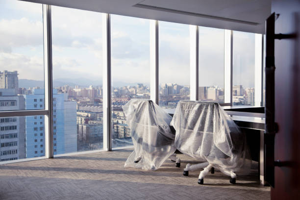 sillas de oficina cubiertas con envoltura de burbujas en un moderno estudio de oficina - going out of business fotografías e imágenes de stock