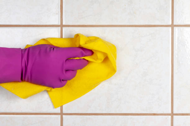 istock A gloved hand holds a rag and washes ceramic tiles. 1149305738