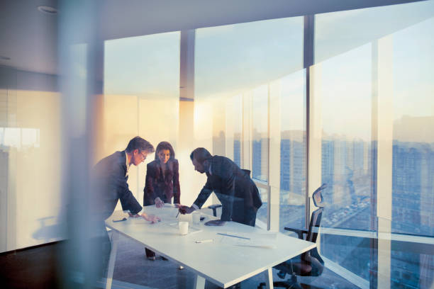 colegas de negocios planeando juntos en la reunión - three people group of people standing business person fotografías e imágenes de stock