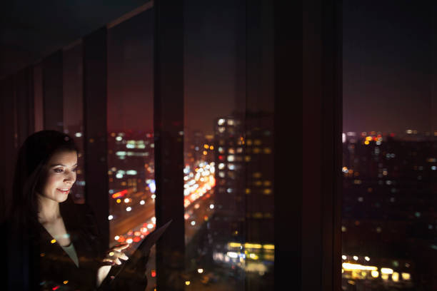 istock Businesswoman looking at tablet computer in office at night 1149306943