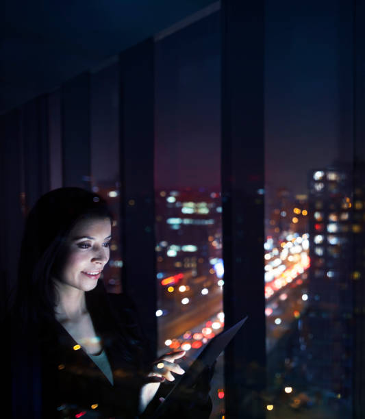 istock Businesswoman looking at tablet computer in studio at night 1149306970