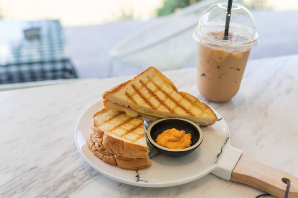 istock Ham cheese sandwich with custard sauce and ice coffee on marble 1149307025