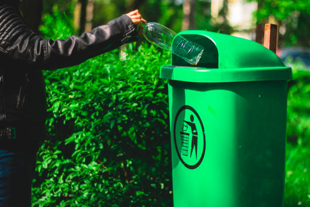 istock Persons hand throwing a plastic bottle in a trash can 1149307131