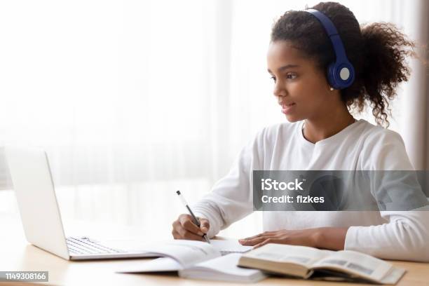 African American Teen Girl Wearing Headphones Learning Language Online Stock Photo - Download Image Now